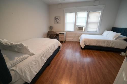- une chambre avec 2 lits et une fenêtre dans l'établissement The Historic Oneida Lake House - Condo 4, à Blossvale