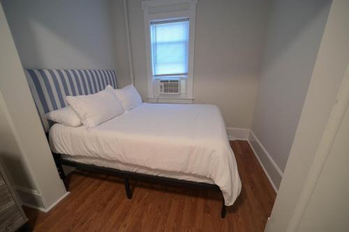 a small bed in a small room with a window at Historic Oneida Lakefront 2BR 1BA Condo 4 in Blossvale