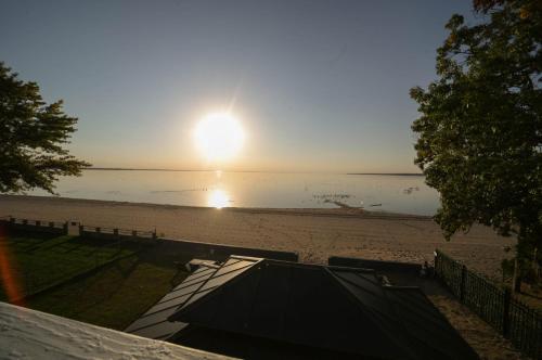 a view of a beach with the sun setting at " The Penthouse" Historic Oneida Lakefront Condo 5 in Blossvale