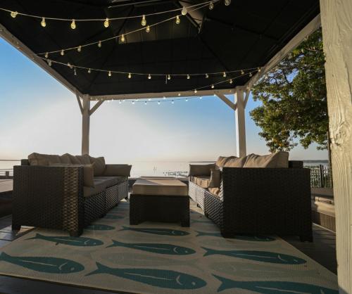 a patio with couches and a table and lights at " The Penthouse" Historic Oneida Lakefront Condo 5 in Blossvale