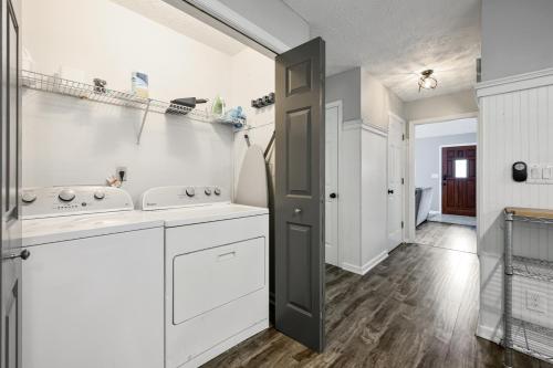 una cocina con armarios blancos y una puerta negra en Relax In This 4BR Retreat With Screened Snug Porch en Marietta