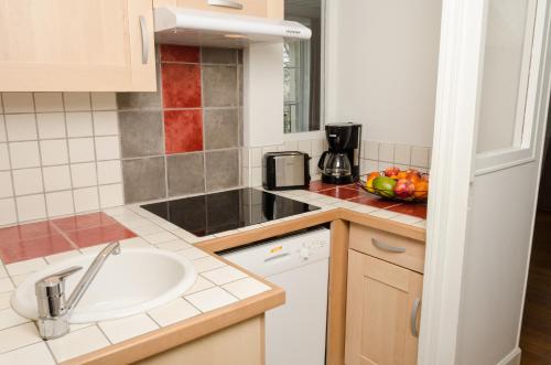 a kitchen with a sink and a bowl of fruit on the counter at Villa Republique Normandie Liberté in Caen