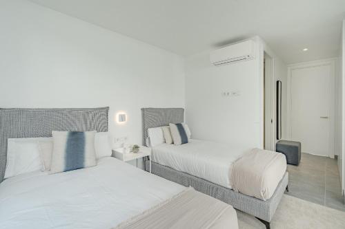 a bedroom with two beds and a chair at Villa Estándar 5 - Casangular by Upper in Adeje