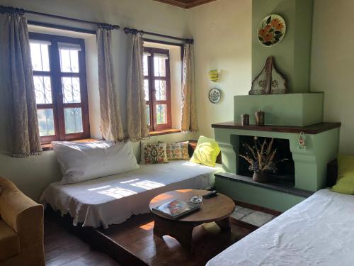 a living room with two beds and a table at Guesthouse Kontogianni - Materka in Nymfaio