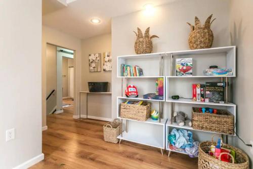 a room with white shelves with baskets and books at Luxurious 5 BR Home in the Heart of Sylvan Beach in Blossvale