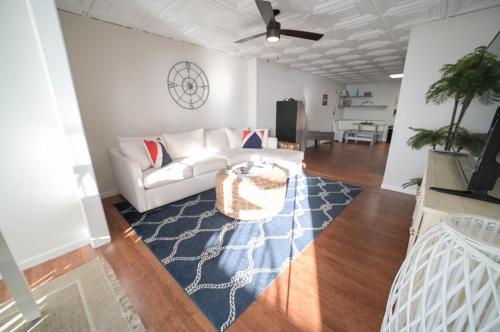 a living room with a white couch and a blue rug at The Historic Oneida Lake House - Condo 2 in Blossvale