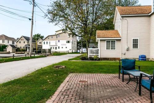 a yard with two blue chairs and a house at Luxurious 5 BR Home in the Heart of Sylvan Beach in Blossvale