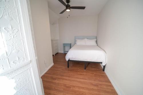 a bedroom with a bed with a ceiling fan at The Historic Oneida Lake House - Condo 2 in Blossvale