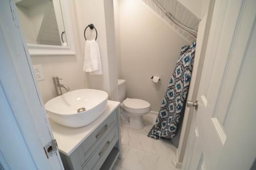 La salle de bains blanche est pourvue d'un lavabo et de toilettes. dans l'établissement The Historic Oneida Lake House - Condo 2, à Blossvale