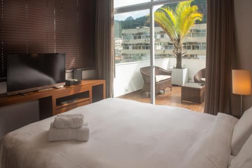 1 dormitorio con 1 cama, TV y balcón en ilive018-2 bedroom Penthouse on Copacabana BEACH, en Río de Janeiro