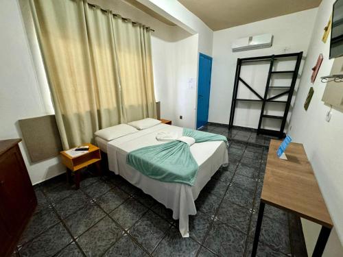 a hotel room with a bed and a window at Pousada Cambará Suítes in Bonito