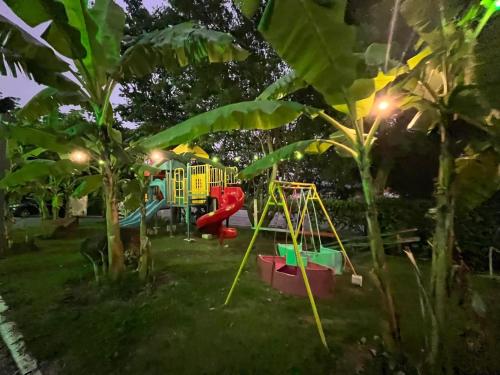 a playground in a park at night with lights at Pousada Jovimar in Aparecida