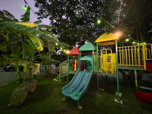 a playground with a slide in the grass at Pousada Jovimar in Aparecida