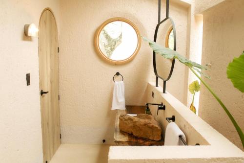 W łazience znajduje się umywalka i lustro. w obiekcie Hotel Tahiti w mieście Puente Iglesias