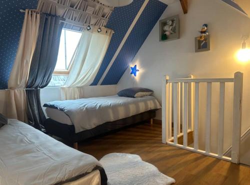 um quarto com 2 camas e um tecto azul em Charmante maison 10 mn Center Parcs Ailette em Laon