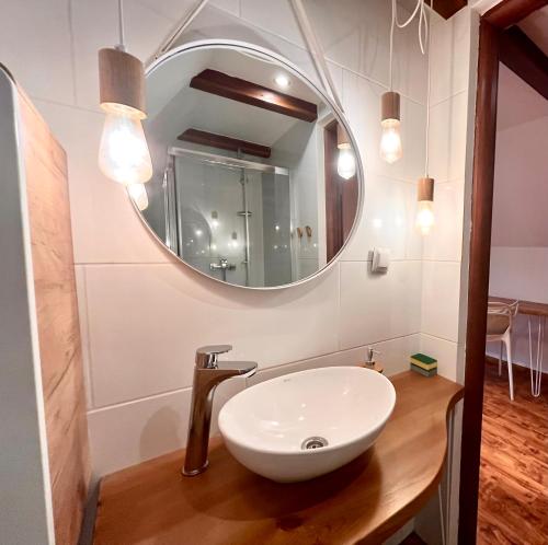a bathroom with a white sink and a mirror at Pokoje i Apartamenty Donia in Ustroń