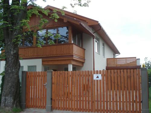 a house with a wooden fence and a tree at Exclusive Mansion Jurmala in Jūrmala