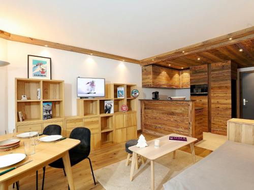 une salle à manger avec des murs en bois, des tables et des chaises dans l'établissement Appartement moderne alpin, balcon, parking, skis aux pieds - 4 à 6 pers. - FR-1-575-108, à Courchevel
