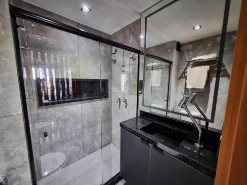W łazience znajduje się prysznic i umywalka. w obiekcie Lobie Nova Iguaçu w mieście Nova Iguaçu