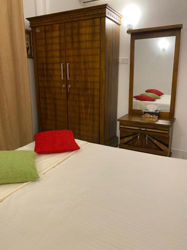 a bedroom with a bed and a dresser and a mirror at Sunshine Holiday Home at Wattala in Wattala