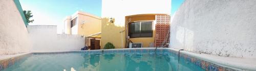 a swimming pool in front of a house with a camper at Piso completo. Hasta 9 personas. Norte MID in Mérida