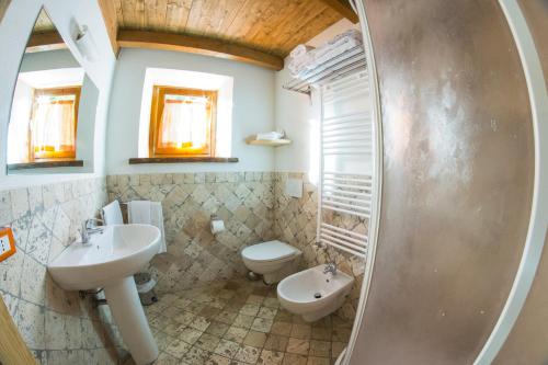 a bathroom with a sink and a toilet and a mirror at Il Borgo Dei Celti in Fiumalbo