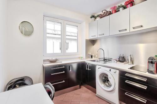 une cuisine avec une machine à laver et un lave-linge dans l'établissement Cosy lyon Opera, à Lyon