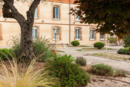 a building with a tree in front of it at ibis Styles Toulouse Lavaur in Lavaur