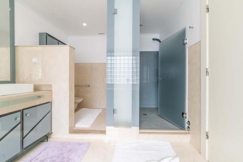 ein Bad mit einer Dusche und einer Glastür in der Unterkunft Villa das Giestas in Quinta do Conde