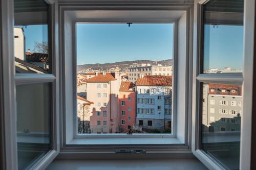 een open raam met uitzicht op de stad bij Le Finestre Boutique Apartments in Trieste