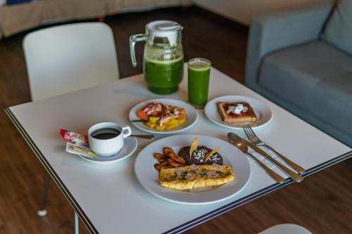 a table topped with plates of breakfast foods and drinks at La Venta Inn Ciudad del Carmen in Ciudad del Carmen