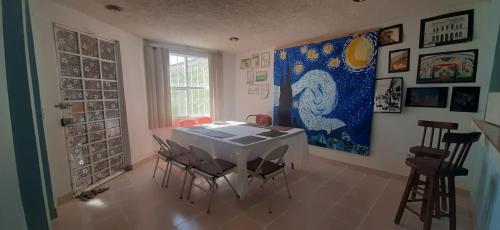 una habitación con una mesa con sillas y una pintura en la pared en Casa Tuzos, en Pachuca de Soto