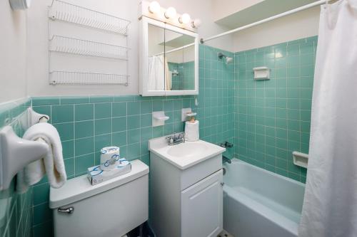 La salle de bains est pourvue d'un lavabo, de toilettes et d'une baignoire. dans l'établissement Seaspray Condos 107B, à Fort Walton Beach