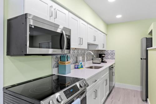 a kitchen with a microwave and a sink at Pirates Cove Cottage at Palm View Inn of Sanibel with Bikes in Sanibel