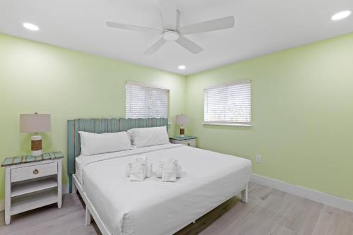 a bedroom with a white bed with two dolls on it at Pirates Cove Cottage at Palm View Inn of Sanibel with Bikes in Sanibel