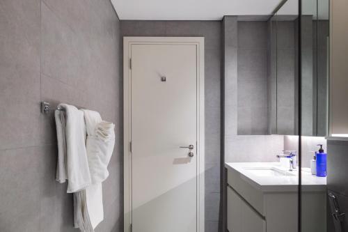 a bathroom with a shower and a white sink at Trophy - Ahad Residence Business Bay Suite in Dubai
