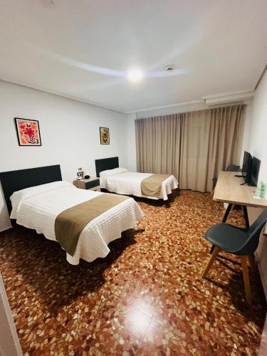 Habitación de hotel con 2 camas y escritorio en Ana Belén, en Granada