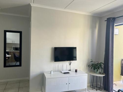 uma sala de estar com televisão numa parede branca em Greenpark Apartment em Kempton Park