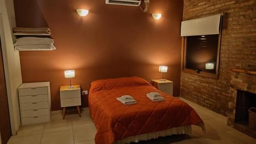 1 dormitorio con 1 cama con 2 toallas en CABAÑAS LOS ARRAYANES en Chascomús