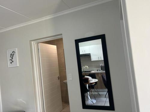 a mirror on a wall next to a kitchen at Greenpark Apartment in Kempton Park