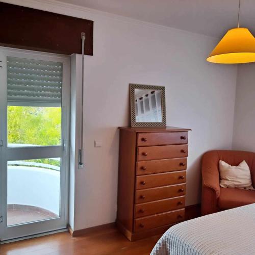 um quarto com uma cama, uma cómoda e uma janela em Casa das Borboletas em Évora