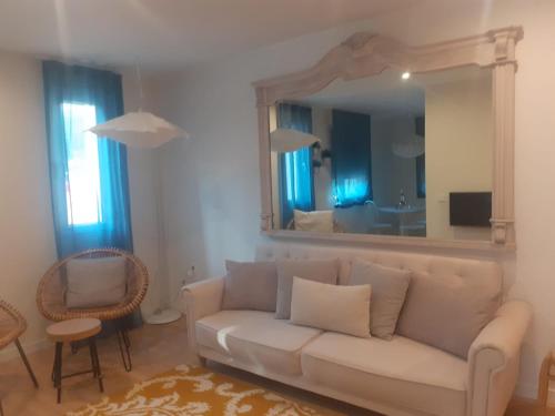a living room with a white couch and a mirror at El Mirador Del Alcazar in Segovia