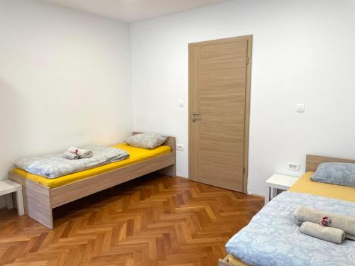 um quarto com 2 camas e piso em madeira em Green Flat Near The City Center With Free Parking em Ljubljana