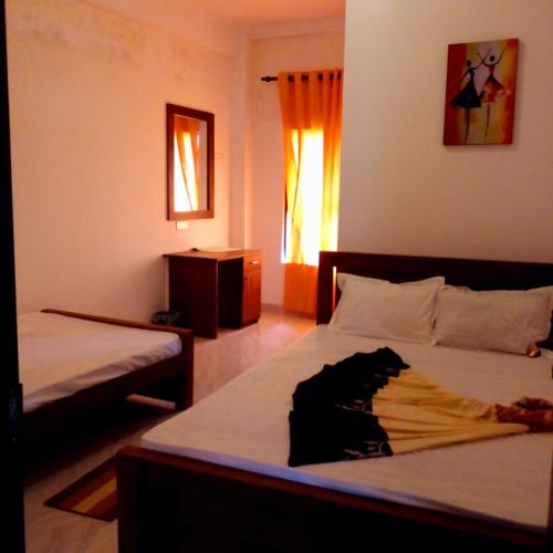 um quarto com 2 camas e uma janela em NIMALA HOLIDAY HOME em Anuradhapura