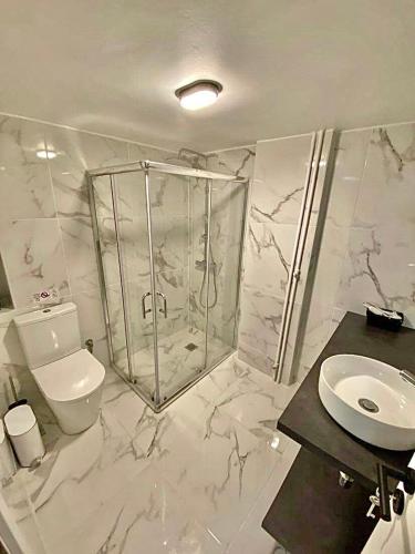 Un baño con ducha, inodoro y lavabo. en Comfortable apartment in the city center, en Atenas