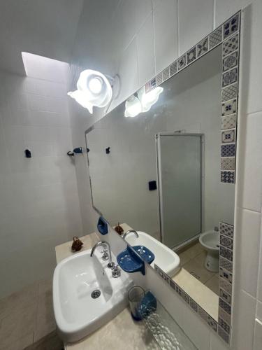 a bathroom with a sink and a toilet and a mirror at Departamento del Centro in Chilecito