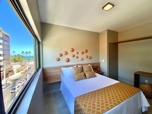 - une chambre avec un lit et une grande fenêtre dans l'établissement Edf. Mar dos corais - a poucos passos do mar, à Maceió