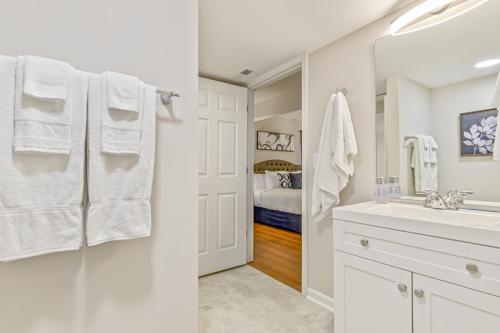 a white bathroom with a sink and a mirror at Cabin Style & Cozy Back Deck Near LakePoint PBR in Cartersville