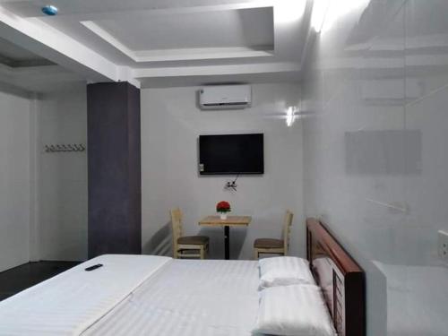 um quarto com uma cama e uma televisão na parede em G7 Hồng Lĩnh em Van Chàng
