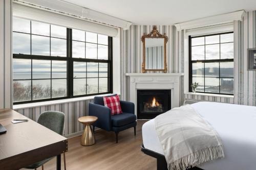 a bedroom with a bed and a chair and a fireplace at Landmark Inn in Marquette
